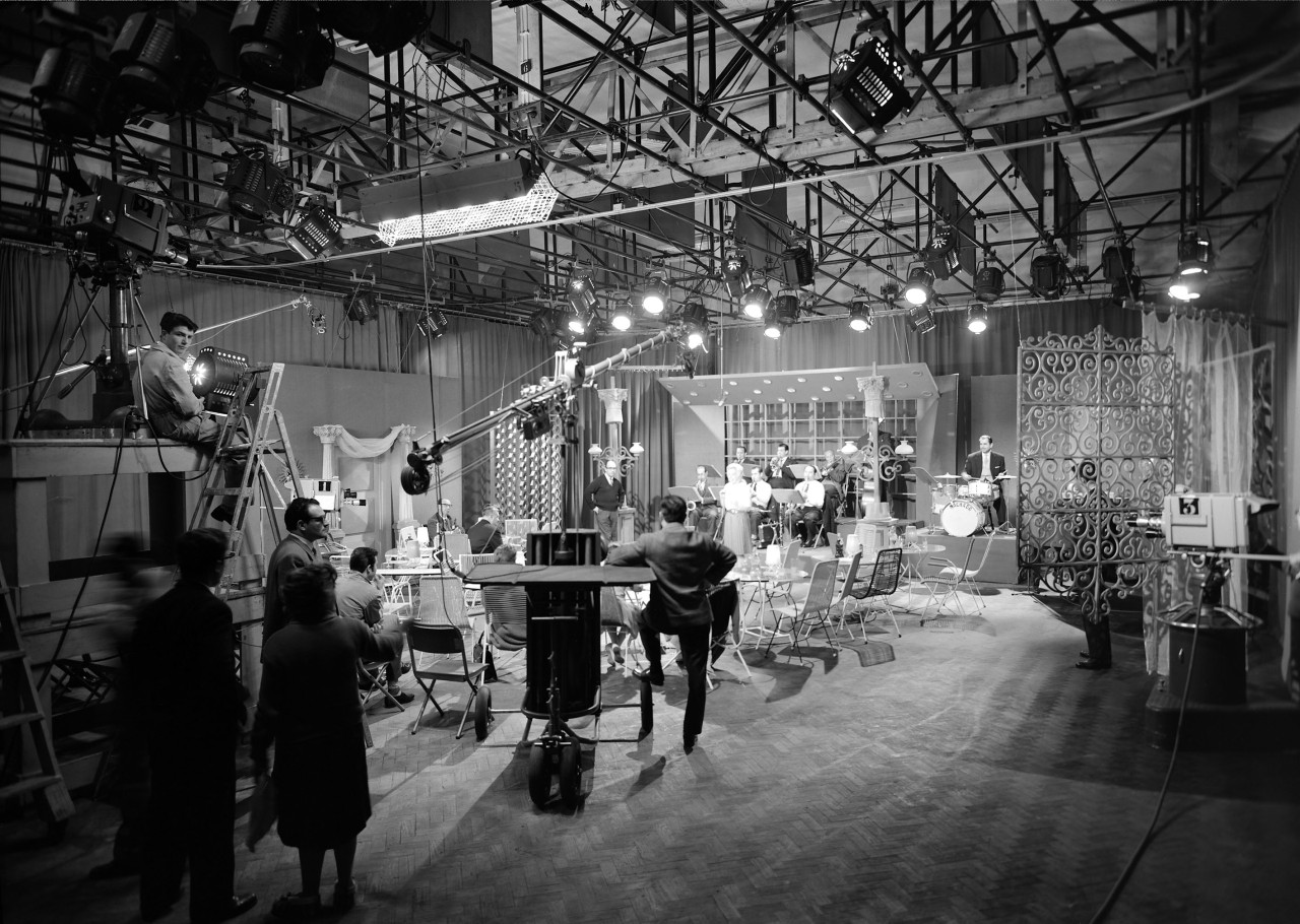 Retro di uno studio di ripresa: strutture, cavi e impianti che sostengono la scena